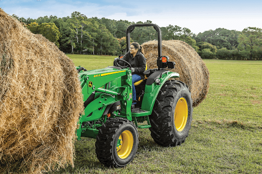 compact tractor lifting round bale