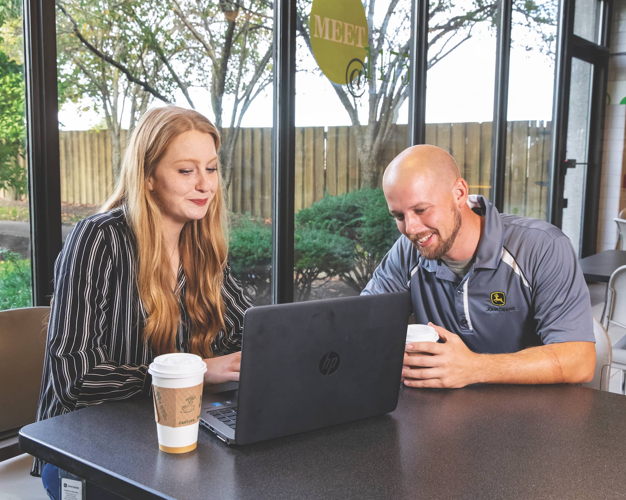 person and service technician sitting in front of laptop at a table